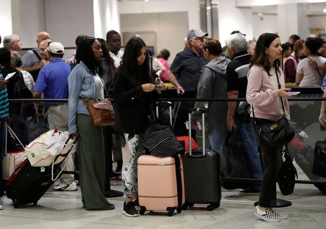FILE- In this Jan. 18, 2019, file photo passengers wait in line at a security checkpoint at Miami International Airport in Miami. While security screeners and air traffic controllers have been told to keep working, Federal Aviation Administration safety inspectors werenâ€™t, until the agency began recalling some Jan. 12. About 2,200 of the more than 3,000 inspectors are now back on the job, overseeing work done by airlines, aircraft manufacturers and repair shops. The government says theyâ€™re doing critical work but forgoing such tasks as issuing new pilot certificates.(AP Photo/Lynne Sladky, File)
