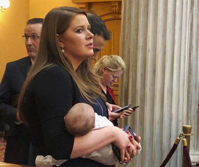 Republican state Rep. Christina Hagan, sponsor of the Ohio heartbeat bill, holds her baby at the back of the Ohio Senate chamber on Thursday, Dec. 27, 2018, in Columbus, Ohio, as she awaits potential Senate action overriding a governorís veto. The billís author, Janet Porter, stands to her right. (AP Photo/Julie Carr Smyth)