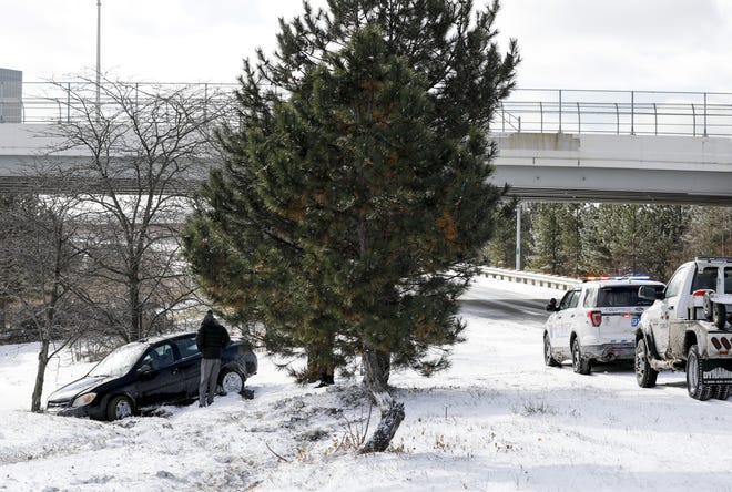 Damon Graham assesses his vehicle after it slid on ice and he lost control on an exit heading toward Convention Center Drive on Sunday, Jan. 20, 2019. Graham said he was grateful he didn't hit any trees. [Tyler Schank/Dispatch]