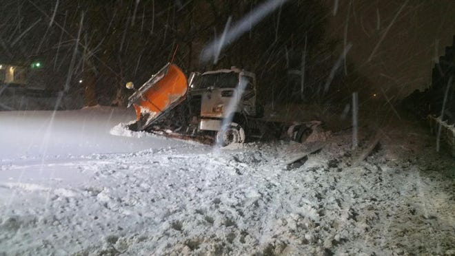A damaged snowplow rests along train tracks on Bailey Road in Cuyahoga Falls after colliding with a train on Sunday night. [Don Walters]