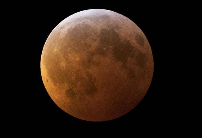 The moon during a total lunar eclipse, seen from West Palm Beach, Monday. The eclipse or blood moon, turns red from sunlight scattering off Earth's atmosphere. [GREG LOVETT/palmbeachpost.com]