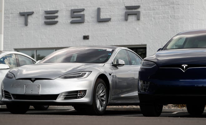 In this July 8, 2018, photo, 2018 Model 3 sedan sits next to a Model X on display outside a Tesla showroom in Littleton, Colo. Tesla CEO Elon Musk announced Tuesday, Aug. 7, that he is considering taking the electric car maker private, causing the company's stock to spike. (AP Photo/David Zalubowski)
