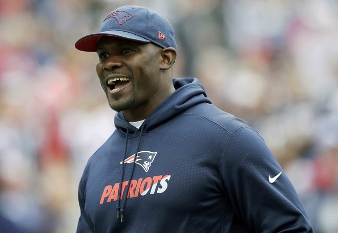New England Patriots linebackers coach Brian Flores watches his team warm up before an NFL football game against the Houston Texans in Foxborough, Mass. [Charles Krupa/AP file]
