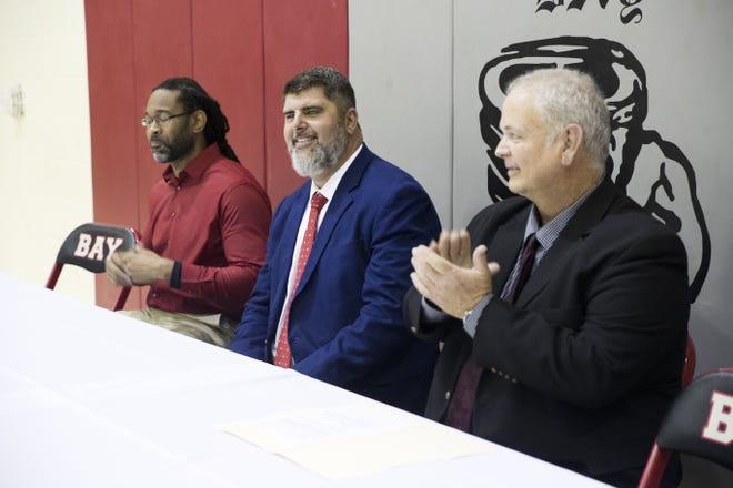Keith Bland, middle, is introduced as the new Bay High football coach by Bay athletic director Michael Grady, left, and Bay principal Billy May. [JOSHUA BOUCHER/THE NEWS HERALD]