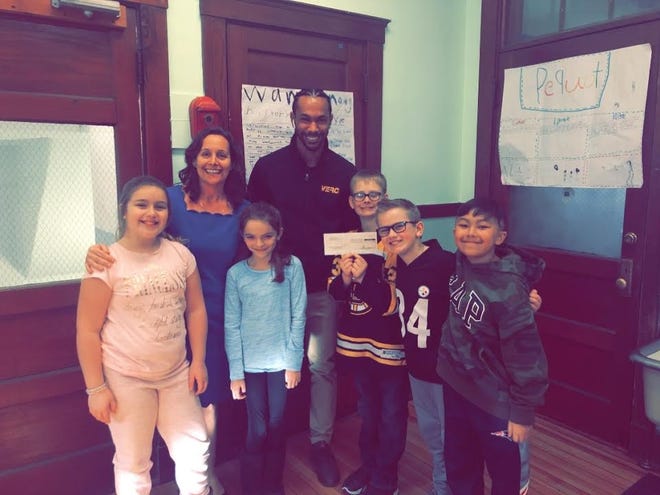Antonio Depina, team leader of the VERC Commerce Way Mobil, presented a check for $500 to students and Kristin Wilson, principal at Hedge Elementary School. [Courtesy Photo]