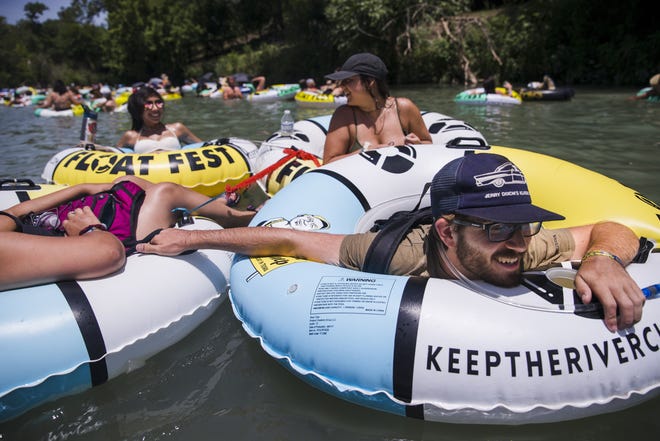 Aaron Dixon, 23, pulls his group along while floating down the San Marcos River during Float Fest on July 22, 2018. Guadalupe County commissioners denied festival organizers a permit to host the event this year. [AMANDA VOISARD/AMERICAN-STATESMAN]