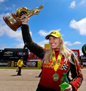 FILE - In this May 21, 2018, file photo, NHRA Funny Car driver Courtney Force raises the Wally Trophy into the air after winning the the Menards NHRA Heartland Nationals at Heartland Motorsports Park in Topeka, Kan. Courtney Force, the winningest female Funny Car driver in NHRA history, is stepping away from driving. Force said in a statement Thursday, Jan. 24, 2019, that stepping away from drag racing was a personal choice as she pursues the next chapter of her life. (Chris Neal/The Topeka Capital-Journal via AP, File)
