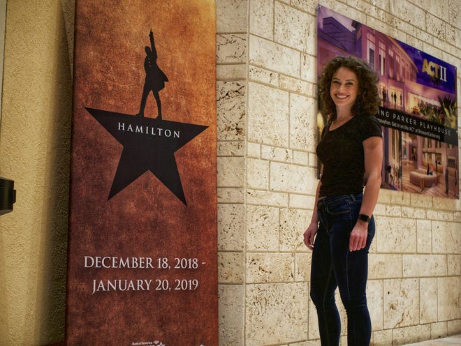 Abby Jaros standing next to the 'Hamilton' poster at the Broward Center for the Performing Arts [WILKINE BRUTUS/palmbeachpost.com]