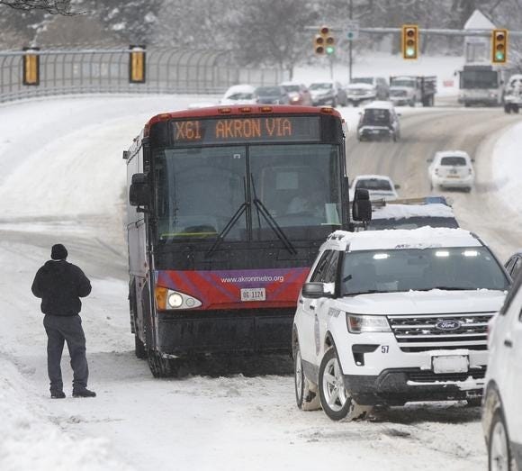 A Metro RTA bus is temporarily stuck on a West Market Street hill at Main Street on Monday. The driver evenutally was able to maneuver up the slick pavement. (GateHouse Media Ohio / Karen Schiely, Beacon Journal / Ohio.com)