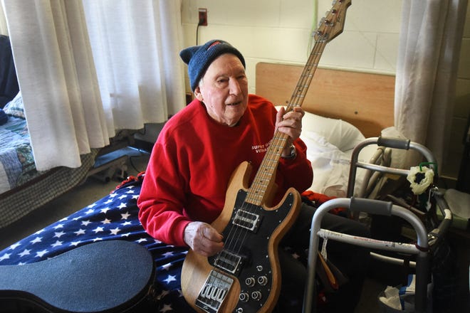 Arnold Hilton, 100, holds his Peavey electric bass guitar and talks about his days of being in bands and how much music has meant to him.
[Deb Cram/Fosters.com]