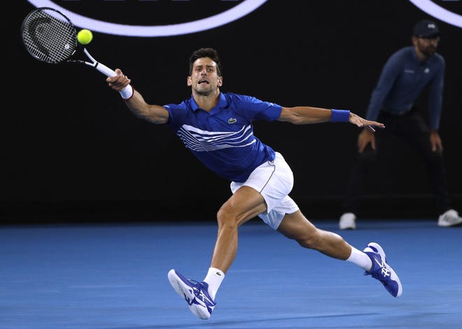 Novak Djokovic makes a forehand return to Lucas Pouille during their semifinal match at the Australian Open tennis championships in Melbourne. [Mark Schiefelbein/AP]