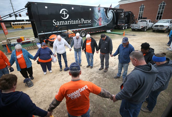 Out of state volunteers with Samaritan's Purse gather to say a prayer before working on homes Jan. 22 at City Church at Northside in Panama City. If you need help, new work orders are being accepted through the end of January. [PATTI BLAKE/THE NEWS HERALD]