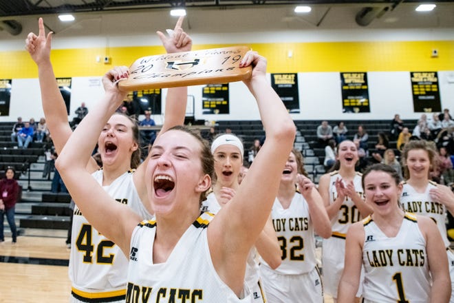 Arie Roper holds up the Wildcat Classic championship trophy as the Haven team cheers after winning the tournament in their final game against Cheney 54-40, Saturday, Jan. 26, 2019 at Haven High School. [Jesse Brothers/HutchNews]