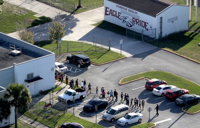 Students are evacuated by police out of Stoneman Douglas High School in Parkland, Fla., after a shooting on Feb. 14, 2018. [Mike Stocker/Sun Sentinel/TNS]