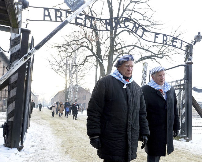 Survivors of Auschwitz gather on the 74th anniversary of the liberation of the former Nazi German death camp in Oswiecim, Poland.. They wore striped scarves that recalled their uniforms, some with the red letter "P," the symbol the Germans used to mark them as Poles. The observances come on International Holocaust Remembrance Day. [Czarek Sokolowski/AP Photo]