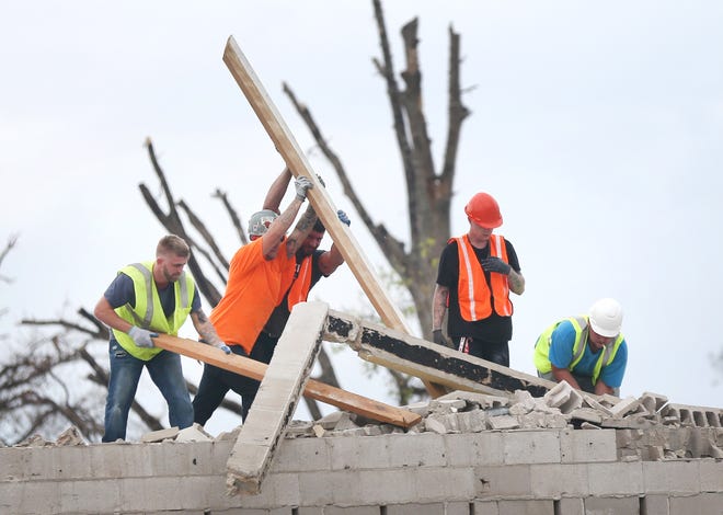 Workers remove debris from the roof of Dan’s Pawn on Nov. 6 in Springfield. [PATTI BLAKE/NEWS HERALD FILE]