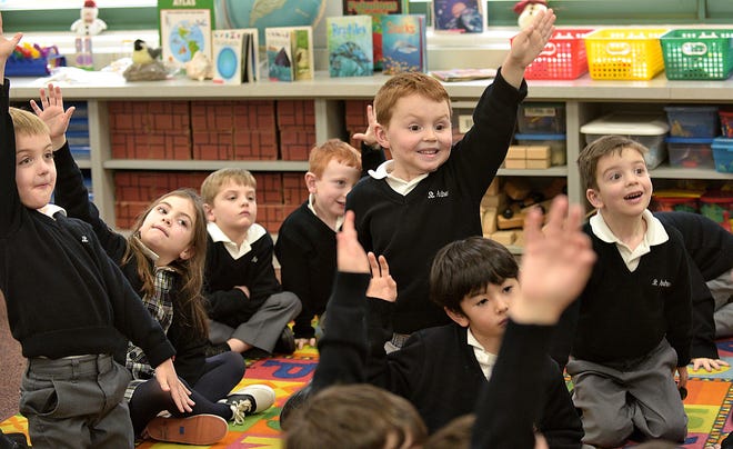 Kindergarten student Michael Egan, center, and his classmates are eager to answer a question at St. Andrew Catholic School in Newtown Township on Thursday. Parochial schools across the country are celebrating Catholic Schools Week. [KIM WEIMER / STAFF PHOTOJOURNALIST]