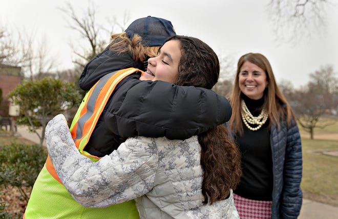 Sixth-grader Abigail Matos gets a hug from crossing guard Meg Wright after receiving a breakfast bag of treats from Matos as Michelle Statler watches Tuesday, at Our Lady of Mount Carmel School in Doylestown Borough. The students packed treats for the people who service their school as part of the many activities taking place for Catholic Schools Week. [KIM WEIMER / STAFF PHOTOJOURNALIST]