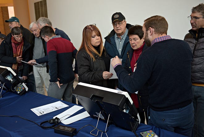 (File) Christopher Houck, right, with Election Systems & Software, explains how paper trails work in voting machines during an expo featuring new voting systems at the Bucks County Administration Building in Doylestown Borough last month. [KIM WEIMER / STAFF PHOTOJOURNALIST]