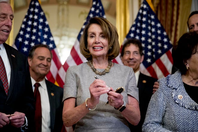 House Speaker Nancy Pelosi of Calif., accompanied by House Democratic members stand after signs a deal to reopen the government on Capitol Hill in Washington, Friday, Jan. 25, 2019. (AP Photo/Andrew Harnik)