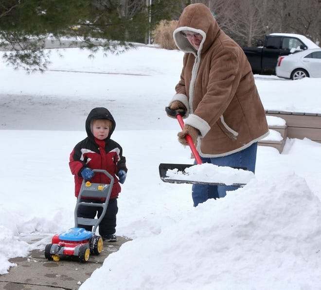 Chase Mohler helps his grandmother Cindy Mohler rid her driveway of snow. [SCOTT HECKEL/CANTON REPOSITORY]