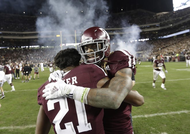 Texas A&M wide receiver Kendrick Rogers, right, celebrates with Charles Oliver (21) after their 74-72 win in seven overtimes against LSU on Nov. 24, 2018, in College Station, Texas. [AP Photo/David J. Phillip, File]