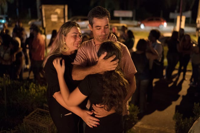 A family embraces during a vigil for the victims of the collapsed mining company dam in Brumadinho, Brazil, Tuesday, Jan. 29, 2019. Authorities arrested five people Tuesday in connection with the collapse of the dam, while the death toll rose to at least 84 and the carcasses of fish floated along the banks of a river downstream that an indigenous community depends on for food and water. (AP Photo/Leo Correa)