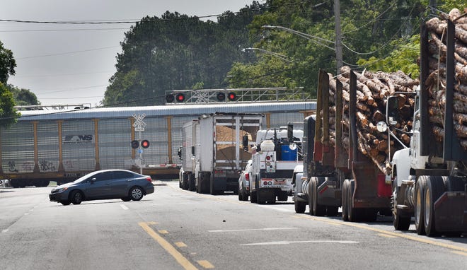 Traffic backs up along U.S. 90 as a long train comes through Baldwin. The roads around Baldwin have been shut down much longer than normal by trains recently, causing problems for residents and businesses. [Will Dickey/Florida Times-Union, File]