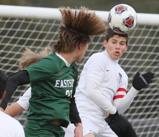 Eastside's Jesse Landis, left, heads the ball toward the Ocala Vanguard goal during the district soccer match at Lake Weir High School in Candler on Wednesday. [Bruce Ackerman/Ocala Star-Banner]