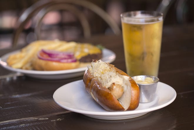 The bratwurst with sauerkraut in a pretzel roll, foreground, and a Willy burger and fries at Plank's Bier Garten [TIM JOHNSON/ALIVE]