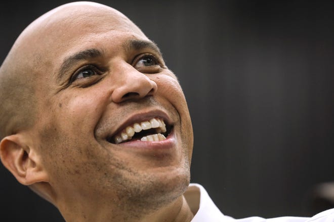 FILE - In this Oct. 28, 2018, file photo, Sen. Cory Booker, D-N.J., looks up as he takes a selfie with an attendee after speaking attends at a get out the vote event hosted by the NH Young Democrats at the University of New Hampshire in Durham, N.H. (AP Photo/ Cheryl Senter, File)