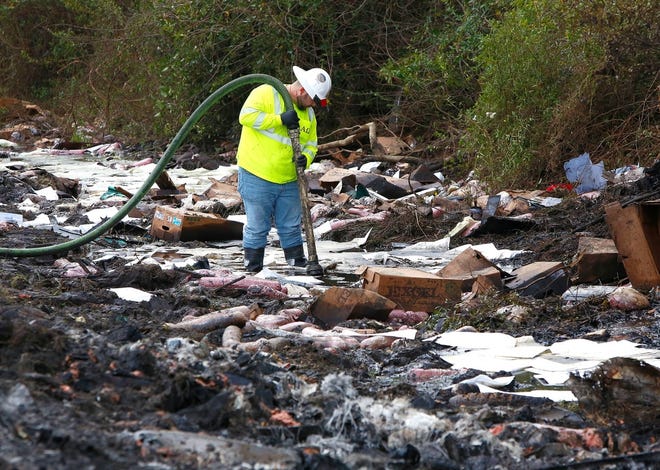 A worker with the environmental clean up company AAG Environmental works the day after the Jan. 3 crash on Interstate 75, which killed seven people and injured more, to remove fuel spilled at the scene. The National Transportation Safety Board is now investigating the crash, along with the Florida Highway Patrol. [Brad McClenny/Staff Photographer]