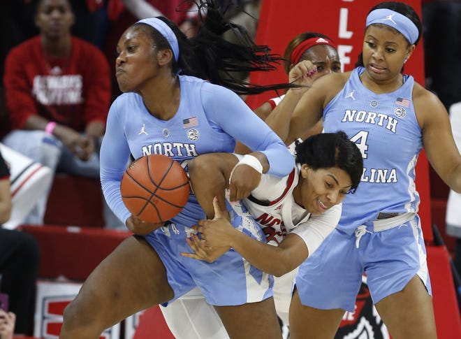 North Carolina's Janelle Bailey and N.C. State's Erika Cassell fight for a rebound in Sunday's game. Bailey had 16 points and 13 rebounds as the Tar Heels handed N.C. State its first loss this season. [Ethan Hyman/The News & Observer via AP]