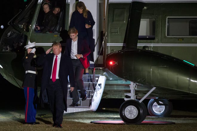 President Donald Trump salutes as he steps off Marine One, accompanied by son Barron Trump and first lady Melania Trump, on the South Lawn of the White House, Sunday, Feb. 3, 2019, in Washington. Trump is returning from a trip to his Florida resort. (AP Photo/Alex Brandon)