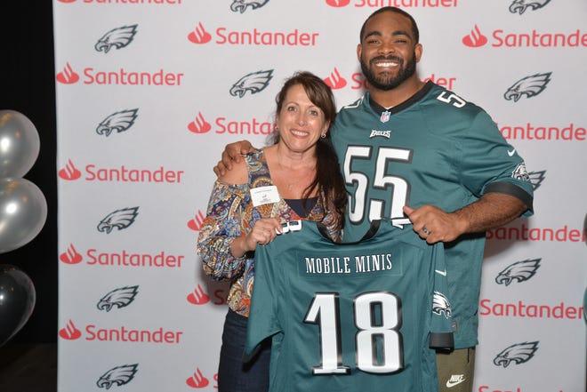 Linda Vataha of Doylestown, left, was honored by Santander Bank, the Philadelphia Eagles, and Eagles defensive end Brandon Graham at the "Santander Community Revolutionaries" reception for her work in the Philadelphia area with Mobile Minis. [COURTESY SANTANDER]