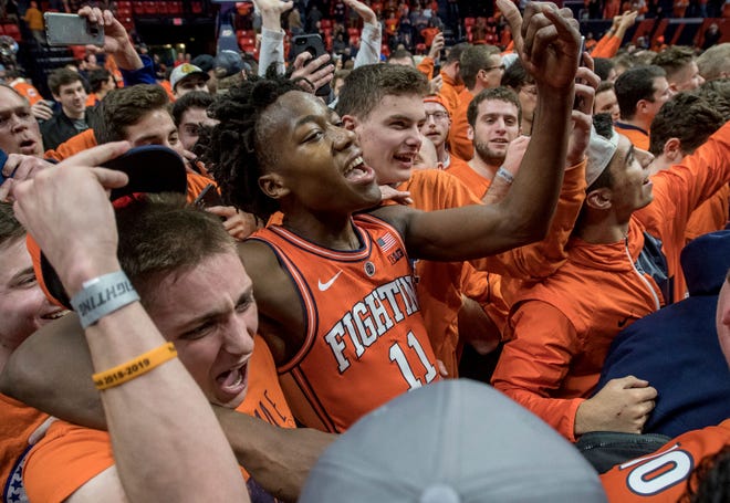 Illinois guard Ayo Dosunmu (11) is swarmed by fans after the 79-74 win over Michigan State. [Rick Danzl/The Associated Press]