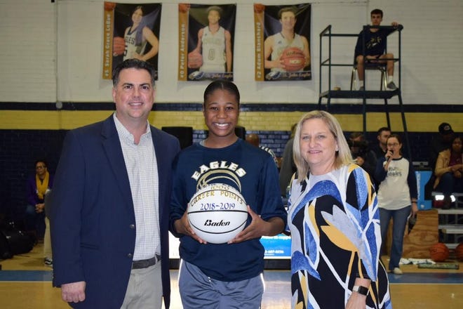J'Nyria Kelly, St. John Freshman, poses with Assistant Girls Basketball Coach Brandon Bueche (left) and Head Coach Cindy Prouty during a presentation honoring her 1000-point season.