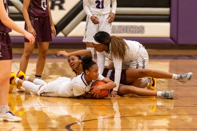Jordyn Marshall ends up with the ball for Cedar Ridge, after she and teammate Timasha Hamilton double-teamed Round Rock's Jaaucklyn Moore. Cedar Ridge won a district girls basketball at home over Round Rock 43-30 on Feb. 5. [Henry Huey for Round Rock Leader.]