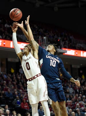 Temple's Alani Moore II, left, and Connecticut's Brendan Adams reach for a loose ball during the first half Wednesday. [Michael Perez / The Associated Press]