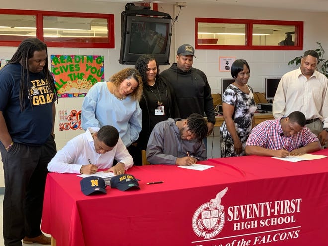 Seventy-First football players, seated left to right, Camari Williams, Benjamin Willis and Thomas Washington signed to play for the U.S. Naval Academy, UNC Pembroke and North Carolina A&T, respectively, in a ceremony at the high school Feb. 6, 2019. [Contributed photo]