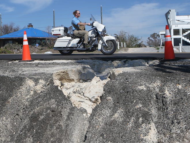A motorcyclist drives over a patched portion of road on U.S. 98 in Mexico Beach on Thursday. [PATTI BLAKE/THE NEWS HERALD]