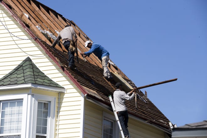 Workers repair a roof in St. Andrews on Thursday. [JOSHUA BOUCHER/THE NEWS HERALD]