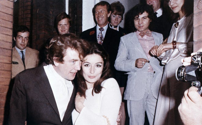 In this 1970 photo, British actor Albert Finney embraces his bride, French Actress Anouk Aimee, after their registry office wedding in London. Finney has died at the age of 82. [AP Photo/Eddie Worth, File]