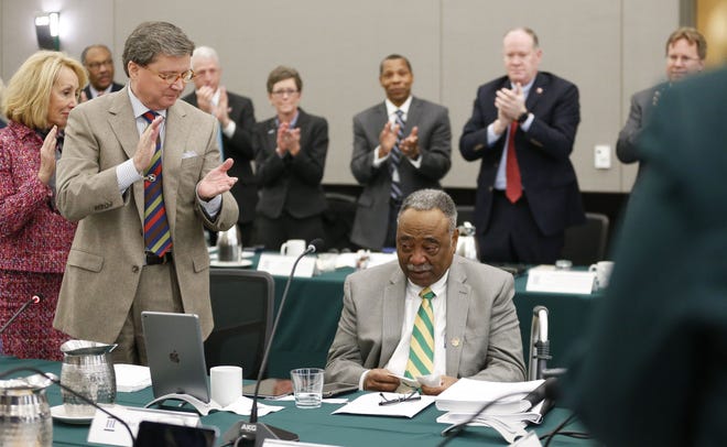The University of Alabama System board of trustees surprised John England Jr. by naming the new freshman residence hall in his honor Friday, Feb. 8, 2019 at the University of Alabama at Birmingham. England, seated, is applauded by his fellow trustees after the announcement was made. [Staff Photo/Gary Cosby Jr.]