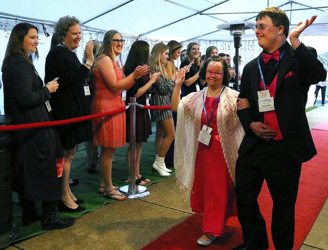 Sarah and Matthew wave as they walk the red carpet into the Night to Shine event at Friday evening at Southminster Church in Gastonia. [JOHN CLARK/THE GASTON GAZETTE]