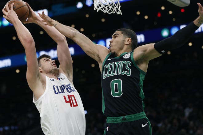 Clippers forward Ivica Zubac (left) shoots against Celtics forward Jayson Tatum during the second half of Boston's 123-112 loss. The Celtics blew a 28 point first half lead and were outscored 70-38 in the second half. [AP Photo/Michael Dwyer]