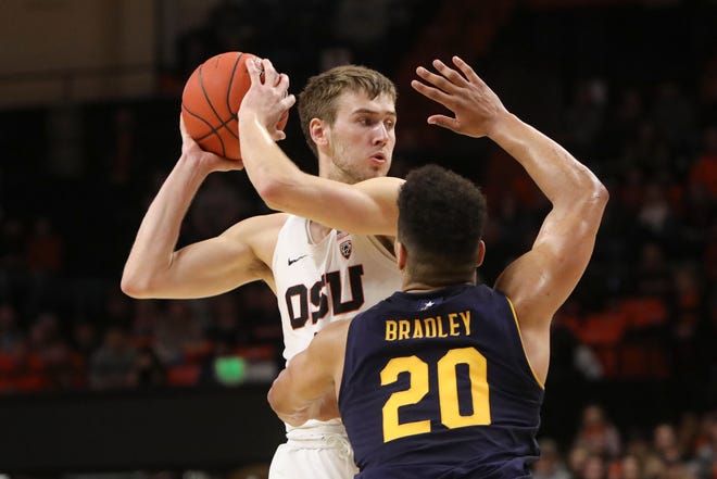 Oregon State's Tres Tinkle, who had 19 points, looks for a teammate to pass to against the defense of California's Matt Bradley (20) during the second half of Saturday's game in Corvallis Oregon State won 79-71. [AP Photo/Amanda Loman]