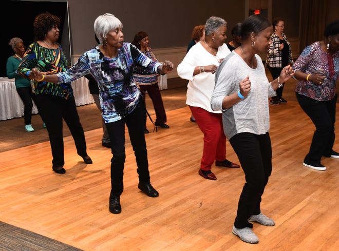 Mary Lewis, center, takes part in the intergenerational line-dancing event at the 30th annual Black Heritage Festival. [Shelly Mobley/savannahnow.com]