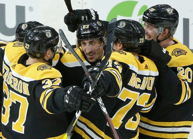 The Bruins' Brad Marchand, center, celebrates with teammates Patrice Bergeron (37), Charlie McAvoy (73) and Joakim Nordstrom (20) after scoring the winning goal in overtime against the Avalanche on Sunday.