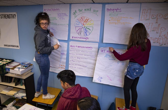 Kimi Hall, left, helps put up planning posters with other students after a brainstorming session for a Sources of Strength class Willamette High School has initiated to address incidents of teen suicide. [Chris Pietsch/The Register-Guard] - registerguard.com